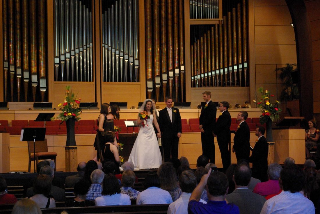 Bride and groom turning to face the congregation after the ceremony, organ pipes behind them