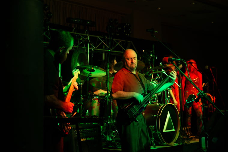Live band performance on dimly lit stage with green and red lights - Portland event photography